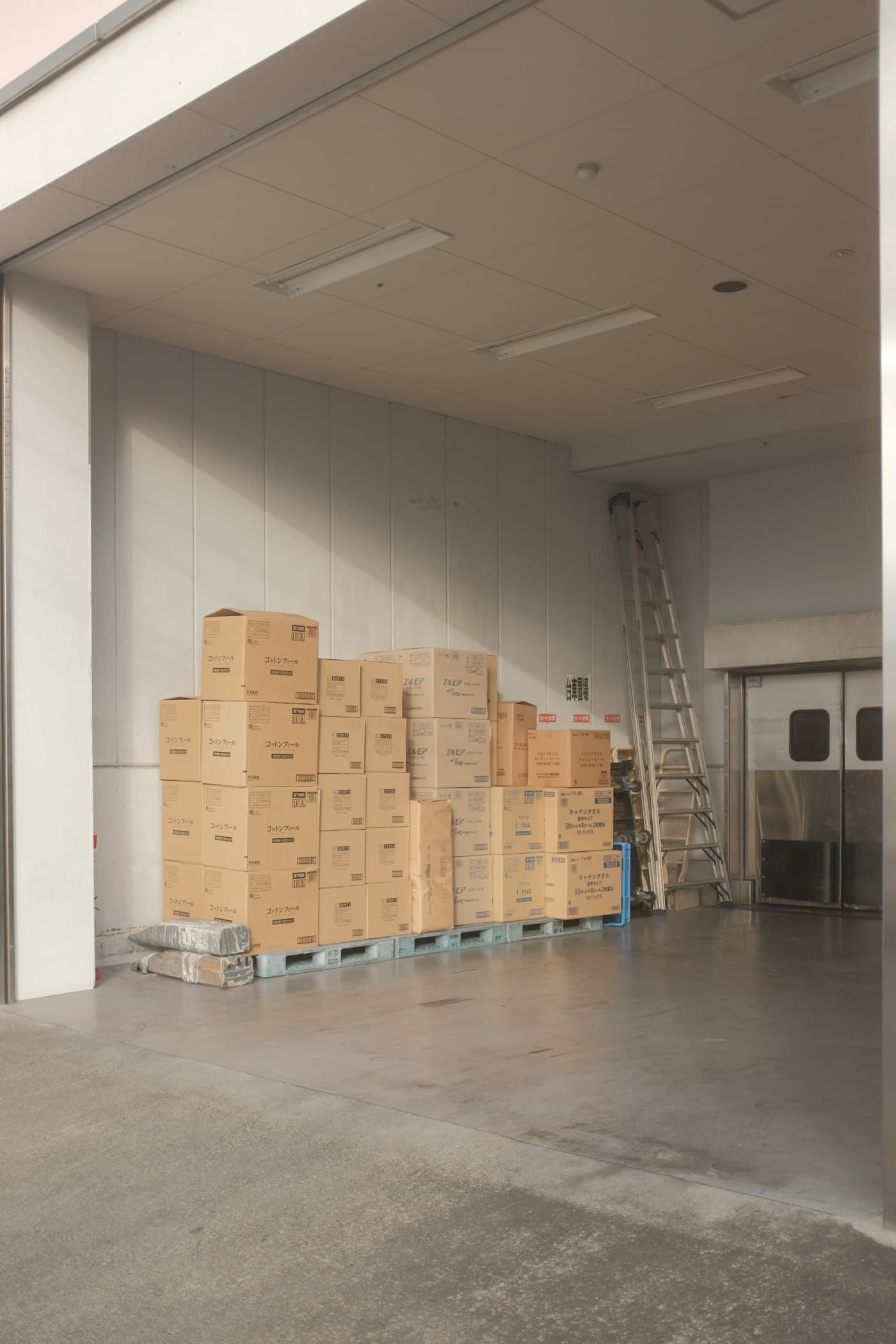 Brown corrugated shipping boxes on a tiled warehouse floor
