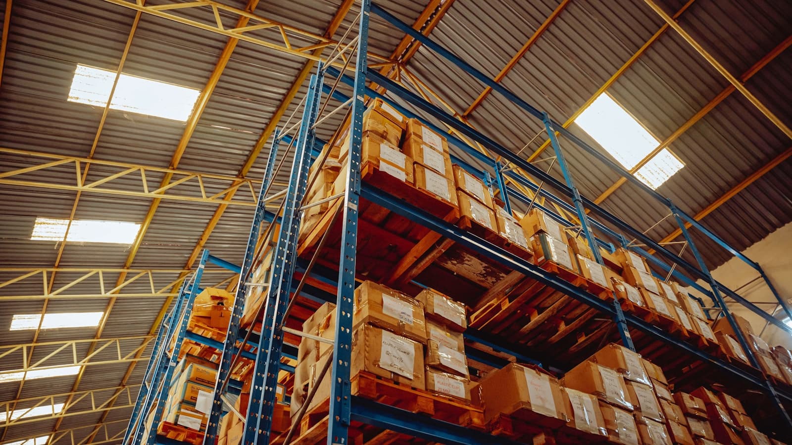 A tall stack of corrugated tote cartons in a warehouse